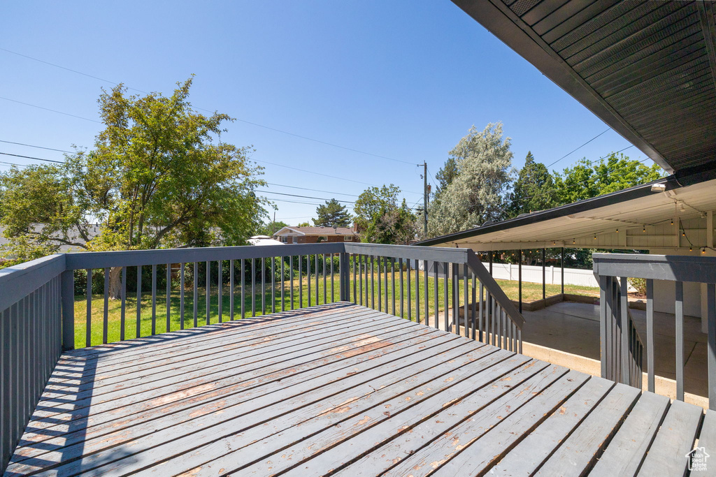 Wooden terrace with a fenced backyard