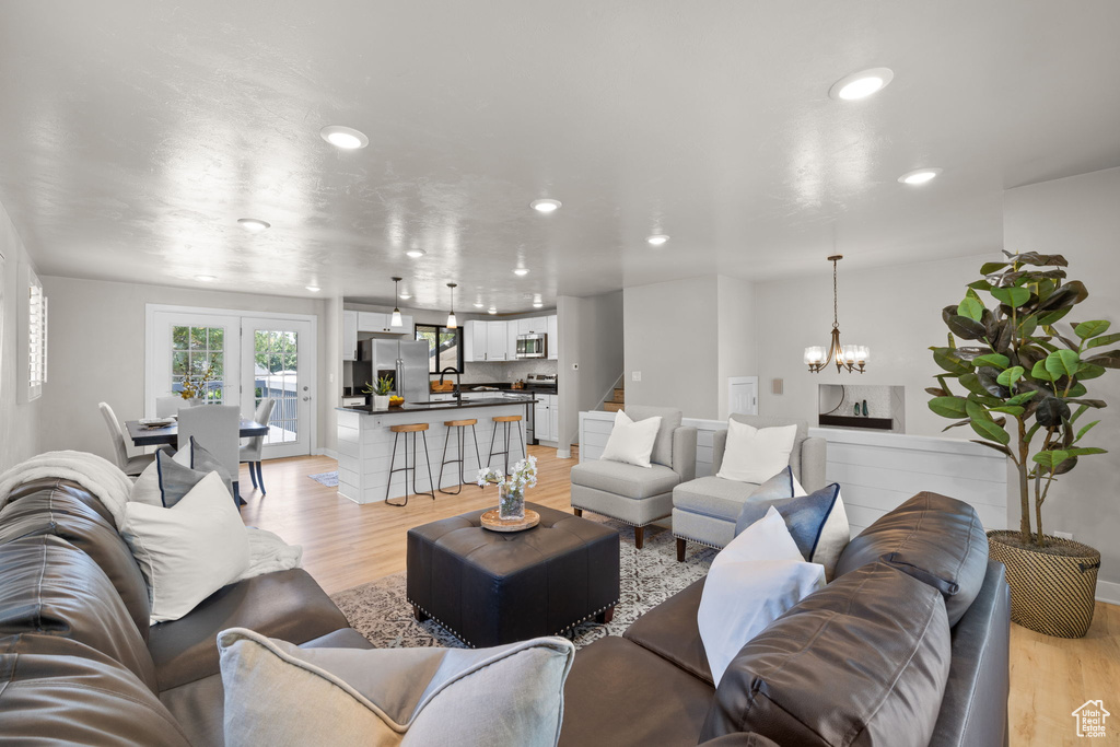 Living area with light wood-style flooring, recessed lighting, and a chandelier