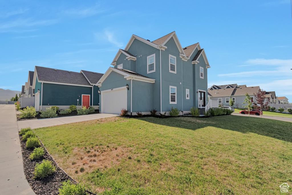 View of front of house featuring concrete driveway, stucco siding, a front lawn, and a garage