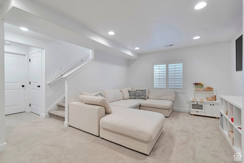 Living room featuring light carpet, recessed lighting, and stairway