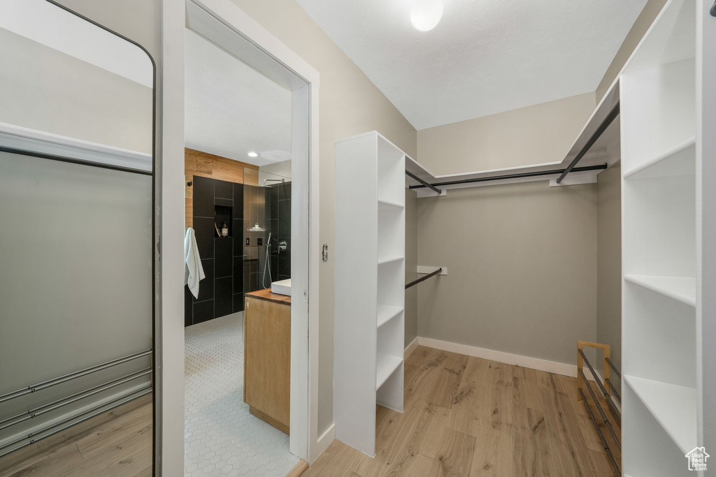 Walk in closet with light wood-style flooring