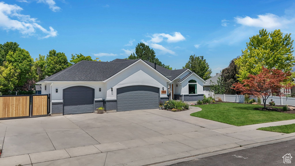 Single story home with an attached garage, stucco siding, and concrete driveway