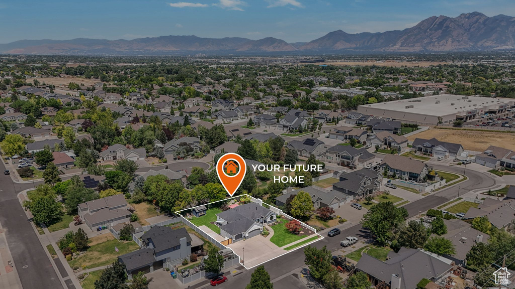 Aerial view of residential area featuring a mountain backdrop and property parcel outlined