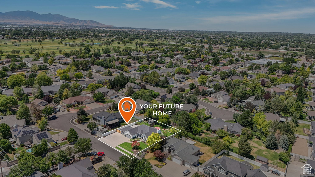 Aerial view of residential area with property parcel outlined and mountains