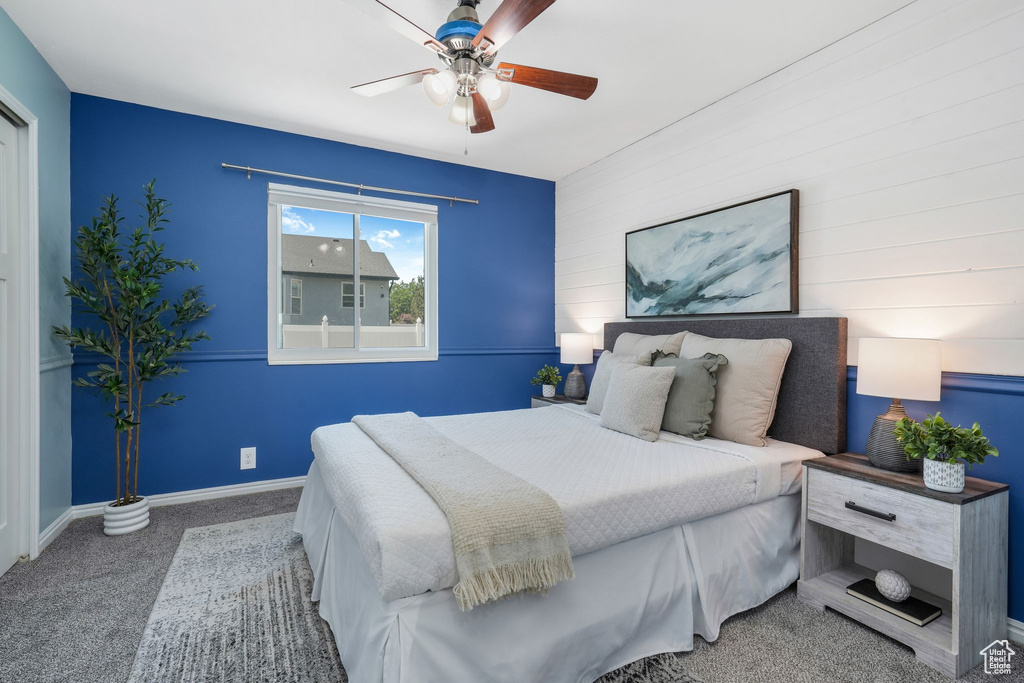 Bedroom with carpet flooring, ceiling fan, and an accent wall