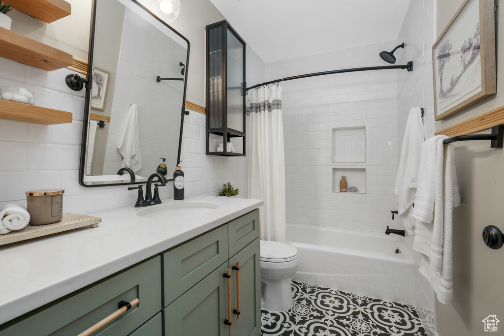Bathroom featuring vanity, shower / bath combo with shower curtain, decorative backsplash, and tile patterned floors