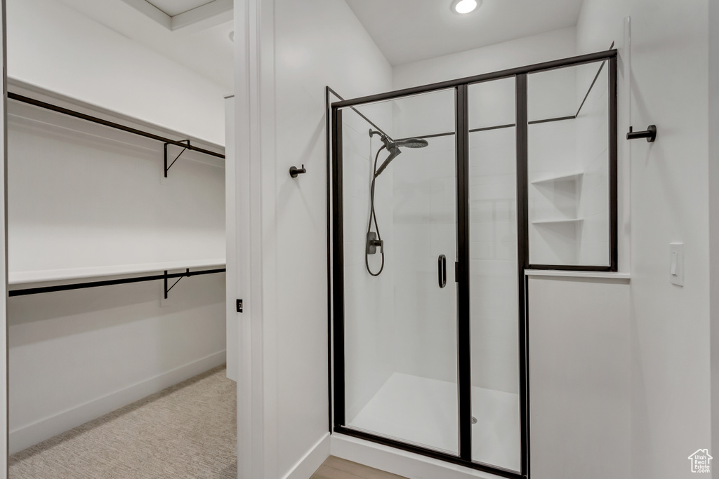 Bathroom featuring a stall shower and a spacious closet