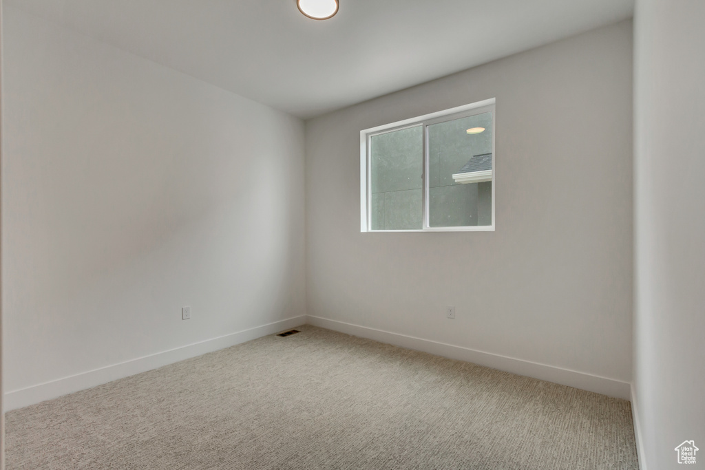 Carpeted empty room featuring baseboards