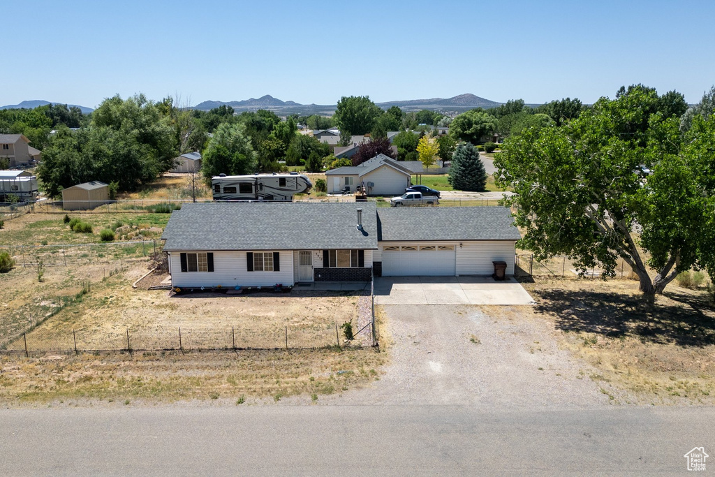 Ranch-style house with a garage, driveway, and a mountain view
