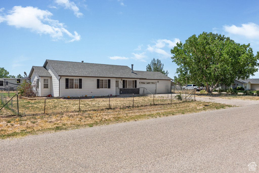 Ranch-style house with a garage, driveway, and a shingled roof