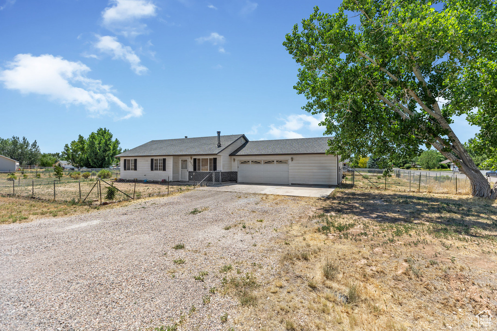Single story home featuring dirt driveway and a garage