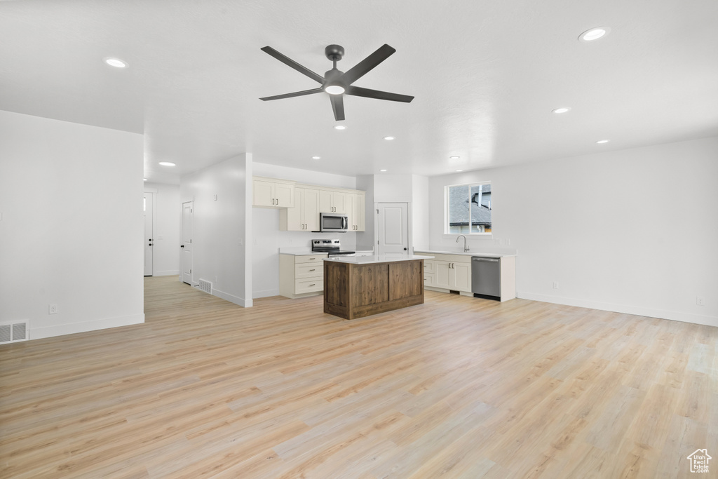 Unfurnished living room with ceiling fan, recessed lighting, and light wood finished floors
