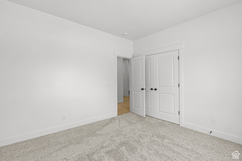 Unfurnished bedroom featuring carpet flooring and a closet