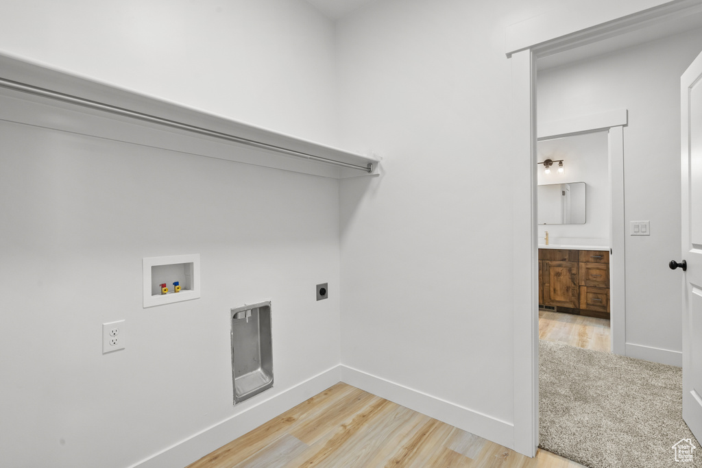 Laundry area featuring hookup for a washing machine, light wood-style floors, and electric dryer hookup