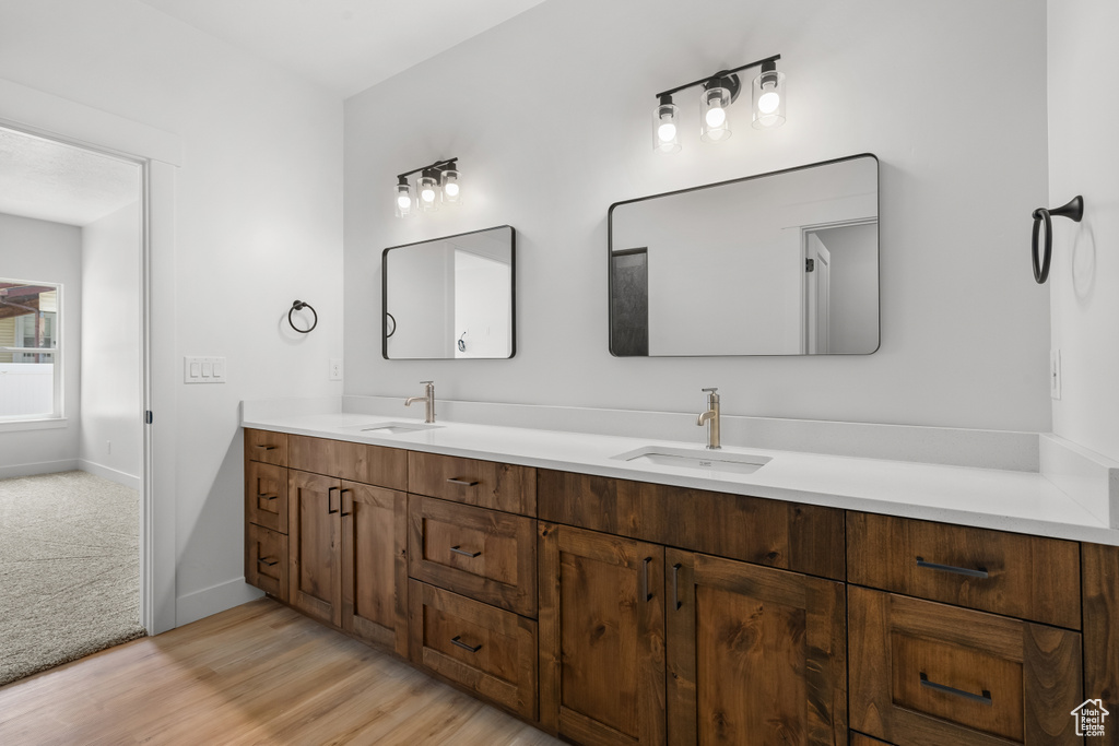 Full bathroom with double vanity and wood finished floors