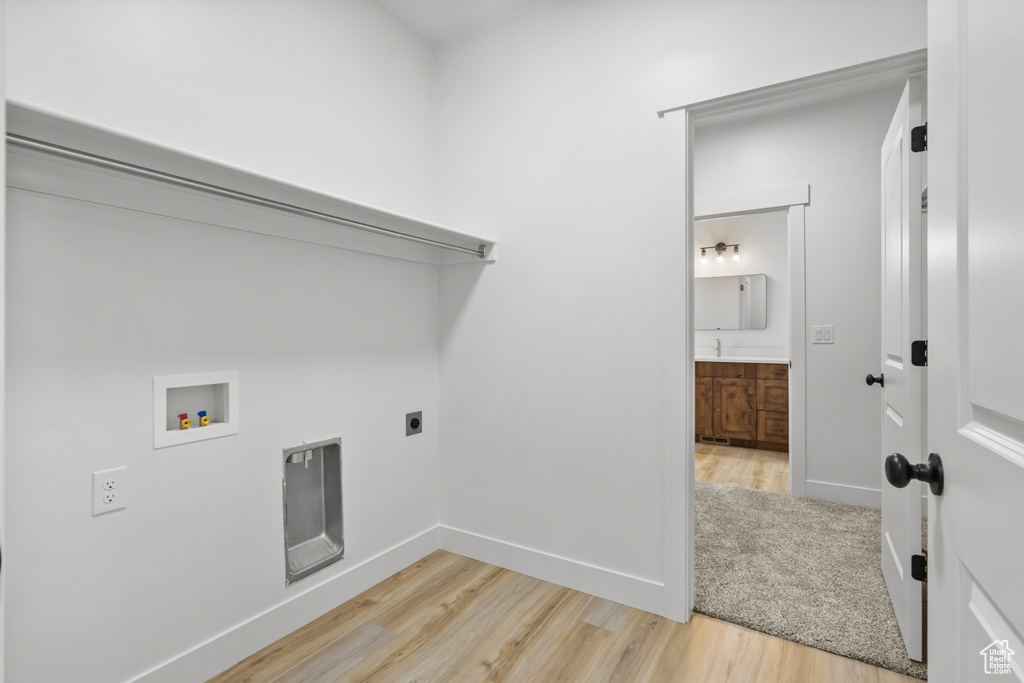 Laundry area featuring hookup for a washing machine, light wood-style flooring, and hookup for an electric dryer