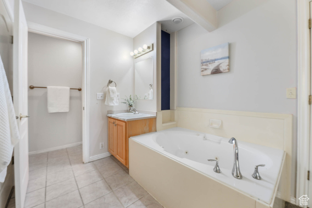 Bathroom with vanity, a tub with jets, and tile patterned flooring
