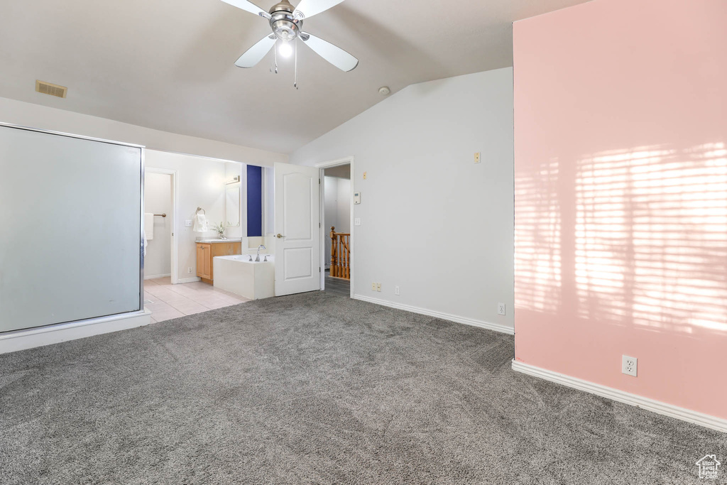 Unfurnished bedroom featuring carpet floors, vaulted ceiling, and ensuite bath