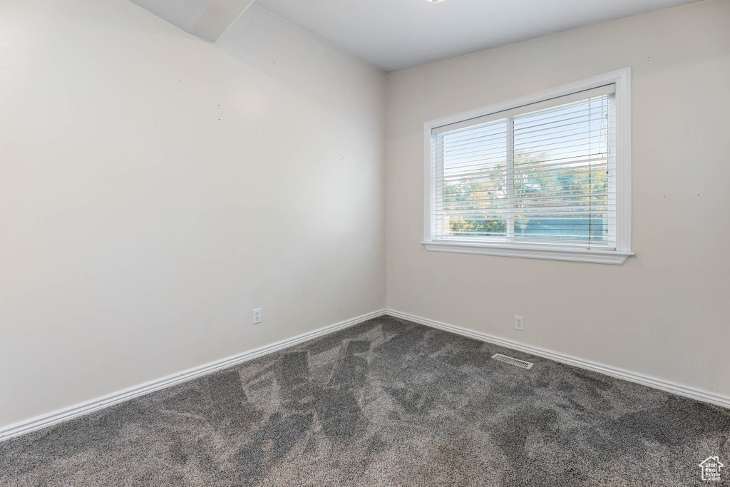 Carpeted empty room with baseboards