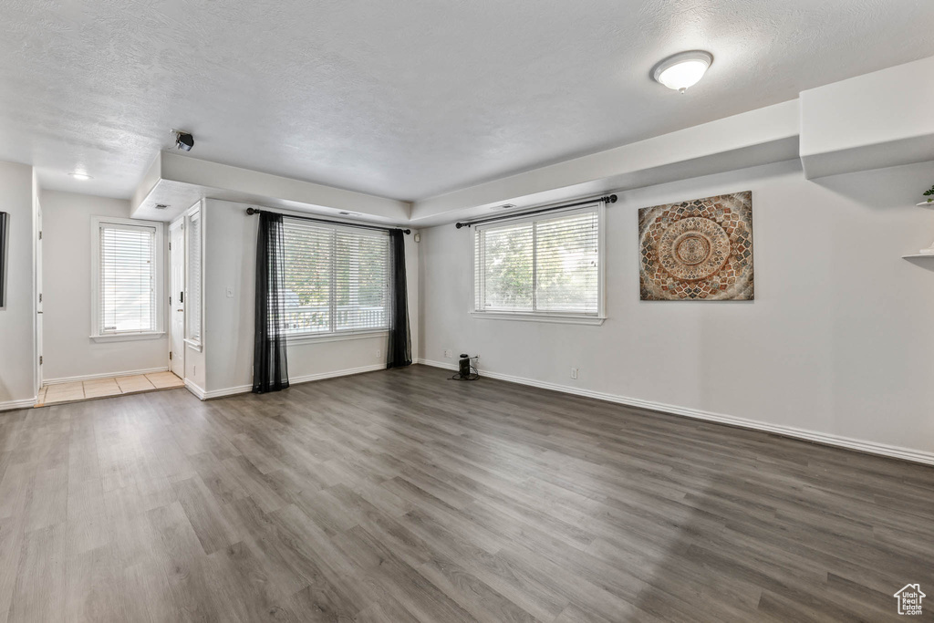Unfurnished living room featuring dark wood-style floors and a textured ceiling