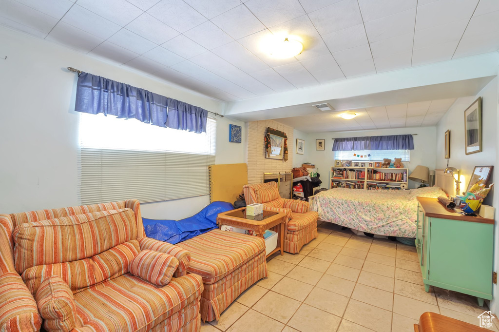 Bedroom with light tile patterned floors and a fireplace