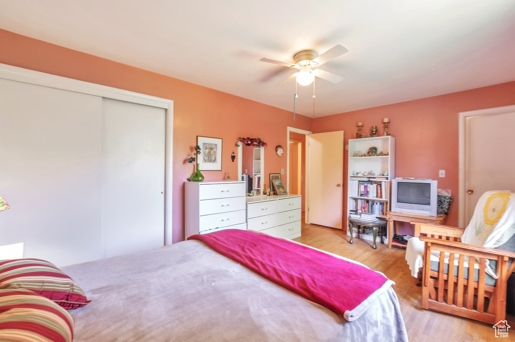 Bedroom with light wood-style flooring, a closet, and ceiling fan