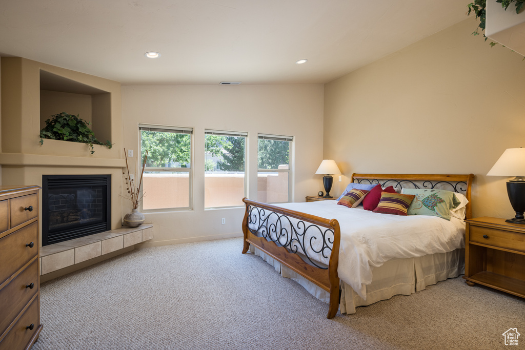 Carpeted bedroom featuring recessed lighting and a tiled fireplace