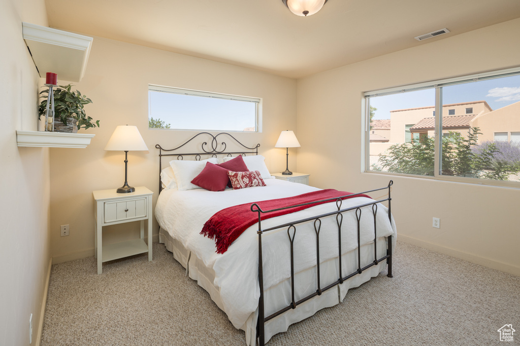 Carpeted bedroom featuring multiple windows