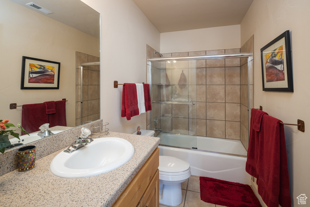 Bathroom with vanity, tile patterned flooring, and bath / shower combo with glass door
