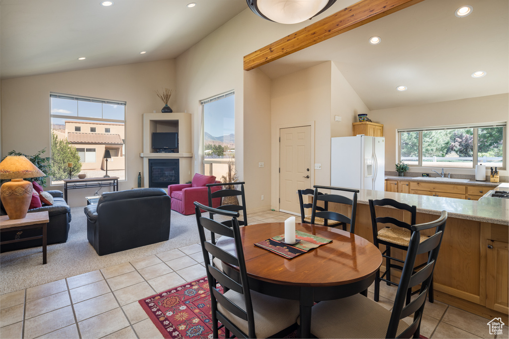 Dining room featuring vaulted ceiling, light tile patterned flooring, recessed lighting, and light colored carpet
