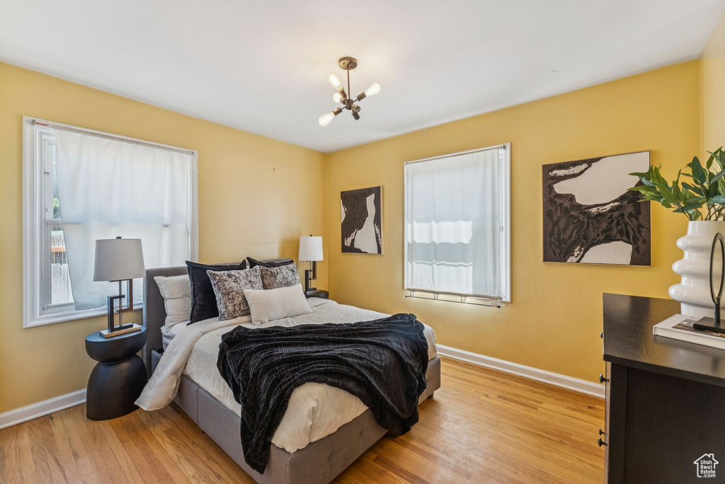 Bedroom with a chandelier and light wood-type flooring