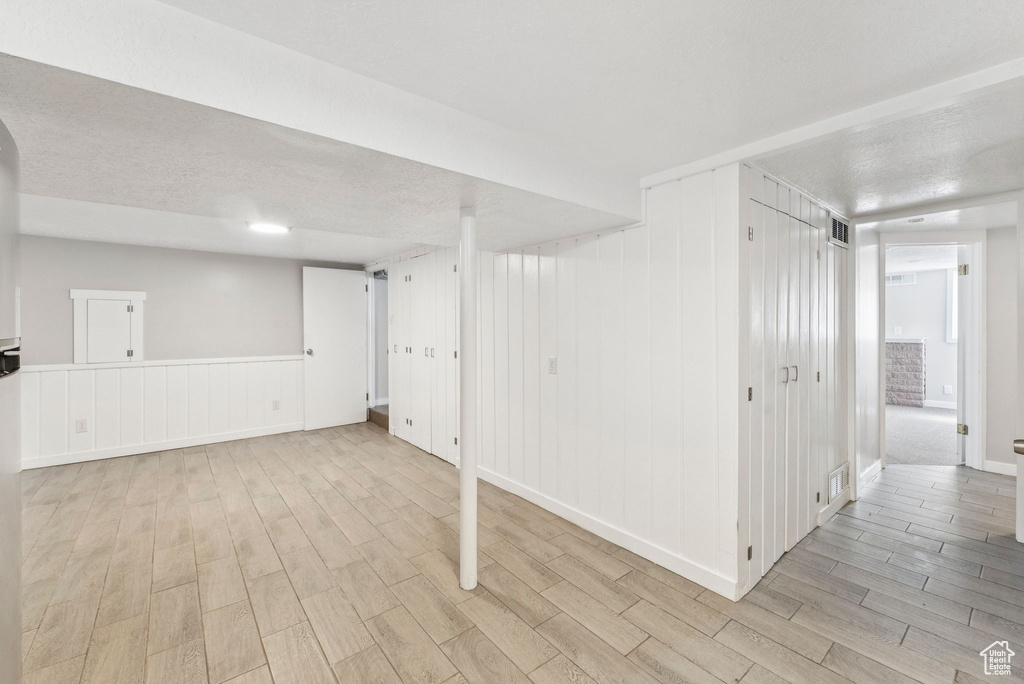 Finished below grade area featuring light wood finished floors and a decorative wall