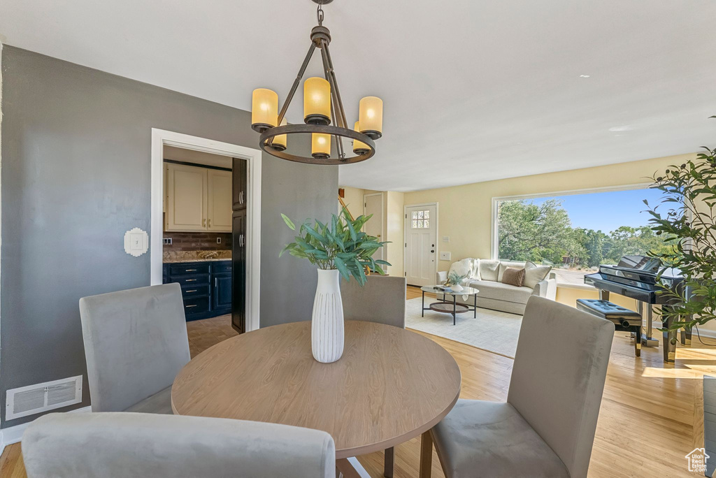 Dining area featuring a chandelier and light wood-type flooring