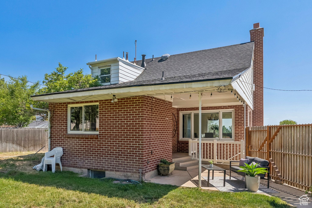 Back of property featuring brick siding and a patio area