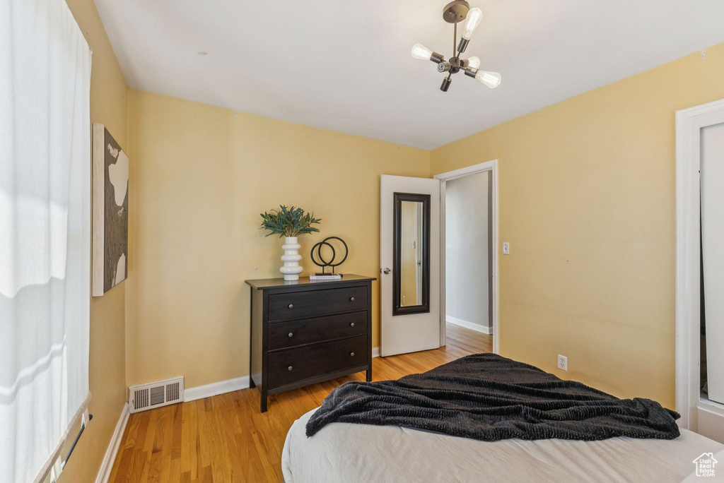 Bedroom with light wood-style floors and a chandelier