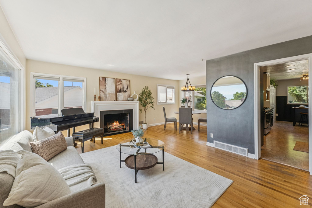 Living area with light wood finished floors and a warm lit fireplace