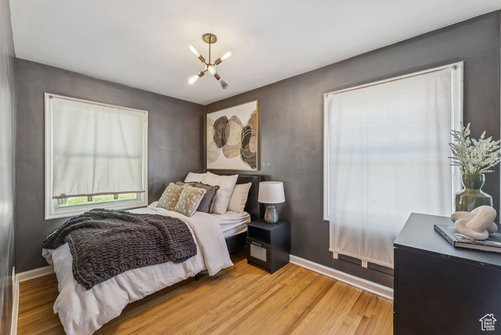 Bedroom featuring a chandelier and light wood-type flooring