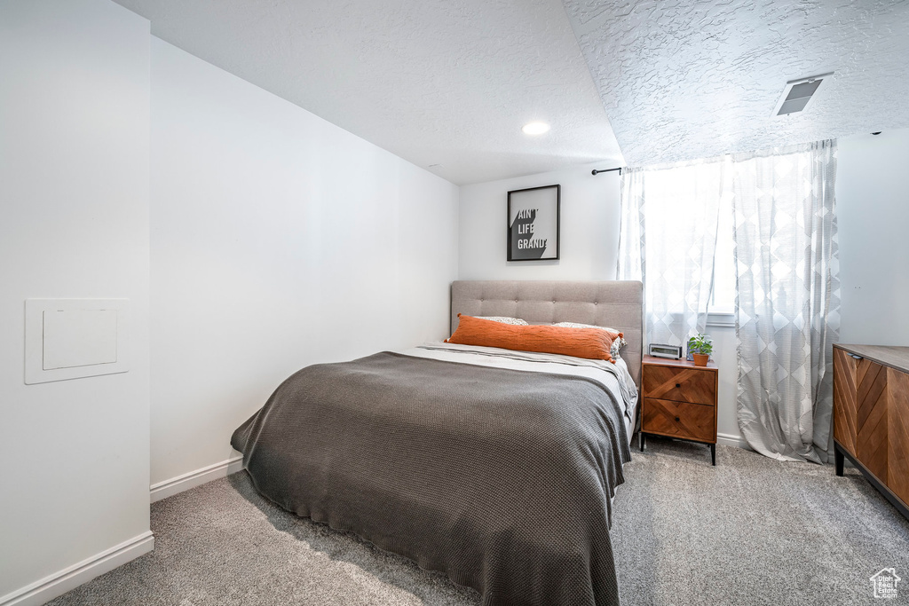 Carpeted bedroom with baseboards and a textured ceiling