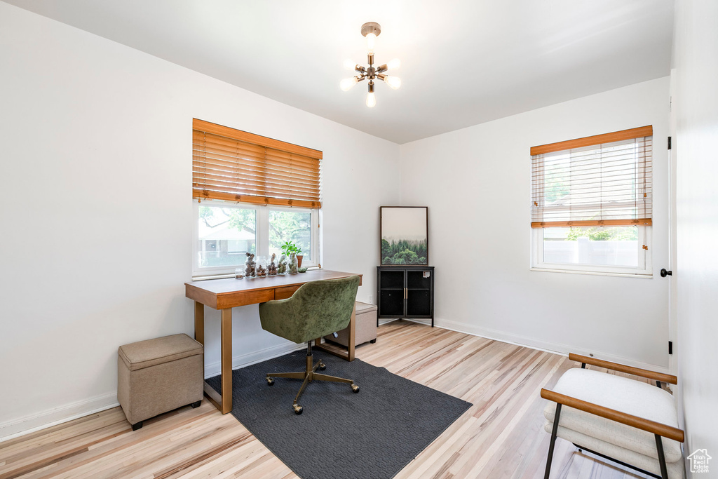 Office featuring healthy amount of natural light, a chandelier, and light wood-type flooring