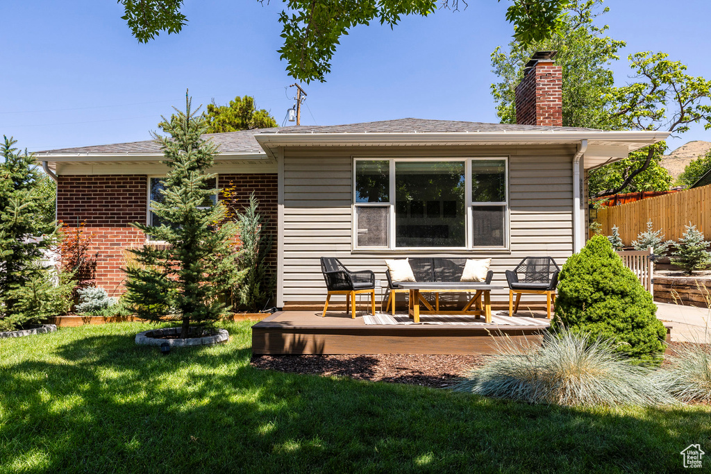 Rear view of property with a wooden deck and a chimney