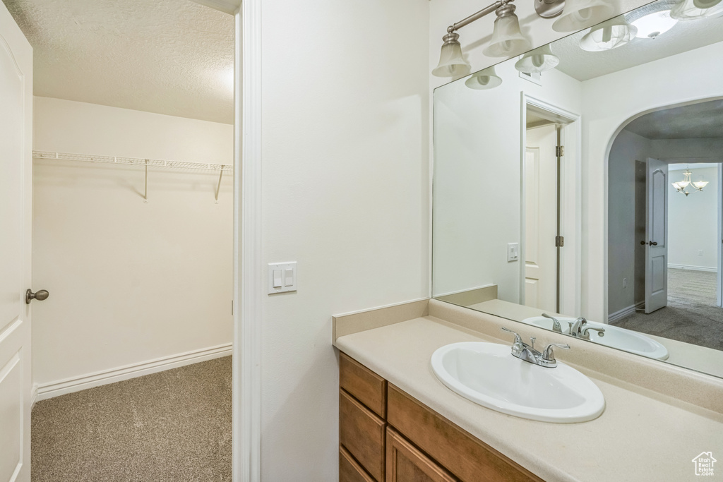 Bathroom featuring vanity and a walk in closet