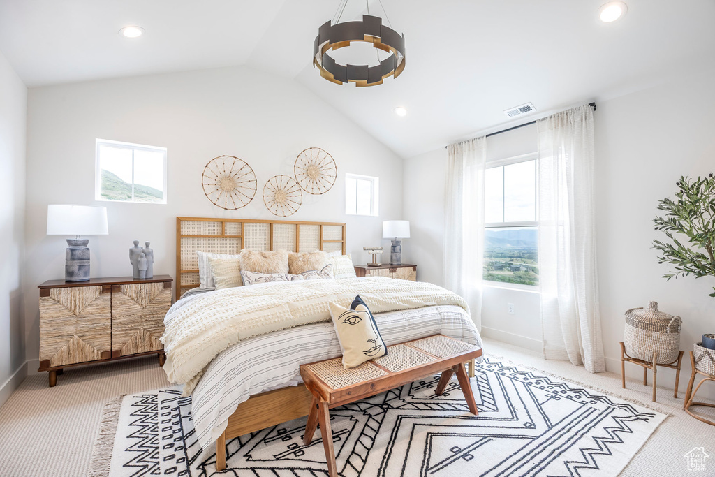 Bedroom with light colored carpet, multiple windows, vaulted ceiling, and recessed lighting