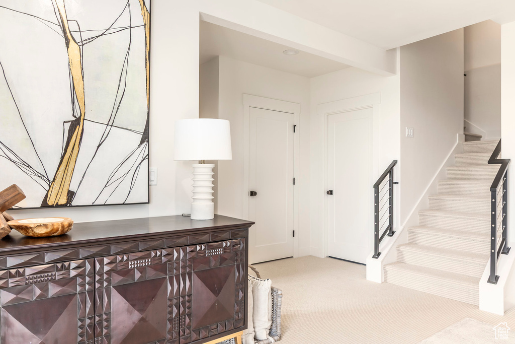 Carpeted entryway featuring stairway