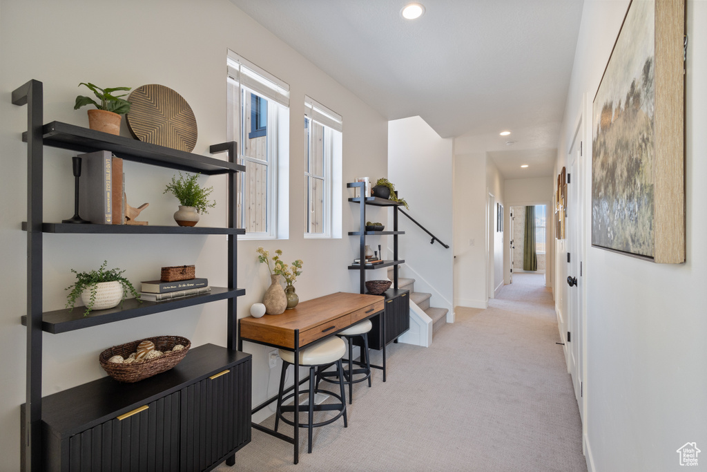Hallway with recessed lighting, light carpet, and stairway