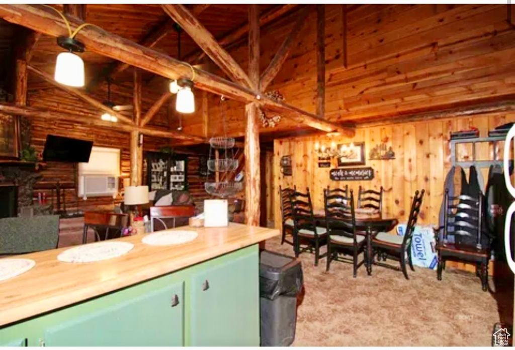 Kitchen featuring high vaulted ceiling, wood walls, beam ceiling, and a fireplace