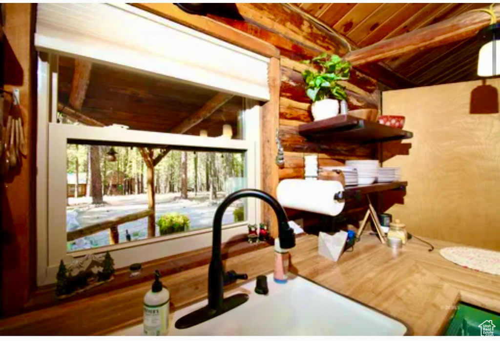 Kitchen view of a sink and a wood ceiling with exposed beams