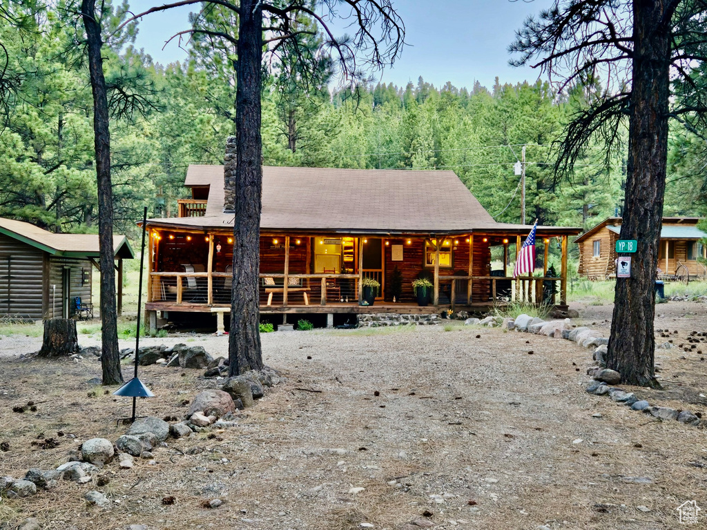 View of front facade with a porch and a wooded view