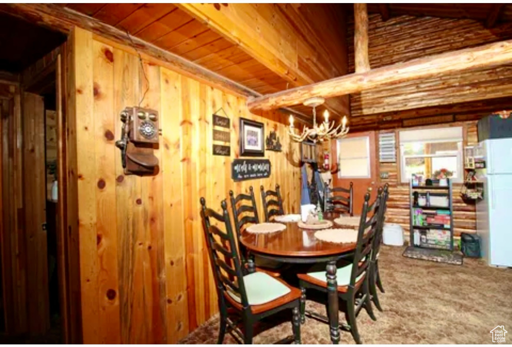 Dining room with a chandelier, carpet, and wood walls