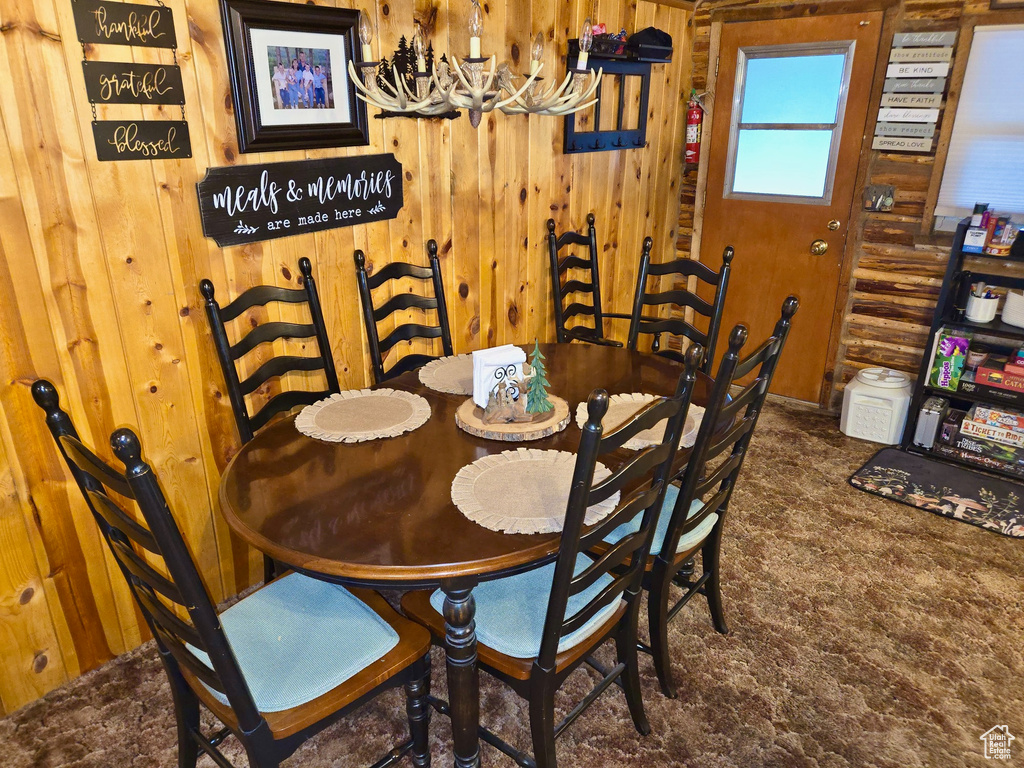 Dining room with a chandelier and wood walls