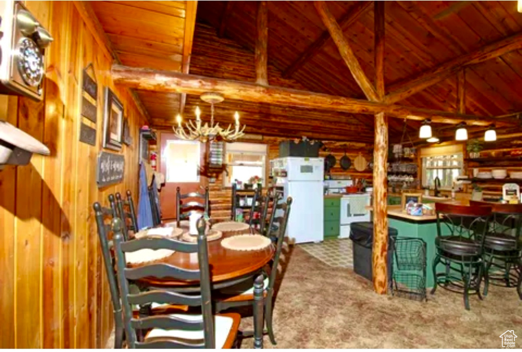Carpeted dining space with wood ceiling, healthy amount of natural light, wood walls, and a chandelier